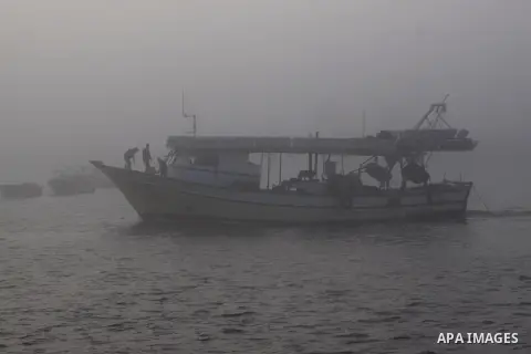 Palestinian fishermen ride their fishing boat at the seaport of Gaza City on December 7, 2014. Israeli forces detained 12 Palestinian fishermen off the coast of the northern Gaza Strip early Sunday. Photo by Mohammed Asa...