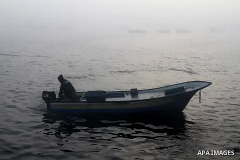 Palestinian fishermen collect boxes of fish at Gaza's seaport of Gaza City on December 7, 2014. Israeli forces detained 12 Palestinian fishermen off the coast of the northern Gaza Strip early Sunday. Photo by Mohammed As...
