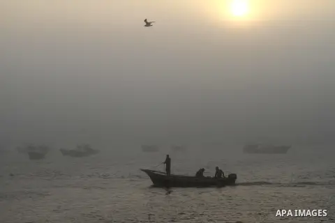 Palestinian fishermen ride their fishing boat at the seaport of Gaza City on December 7, 2014. Israeli forces detained 12 Palestinian fishermen off the coast of the northern Gaza Strip early Sunday. Photo by Mohammed Asa...