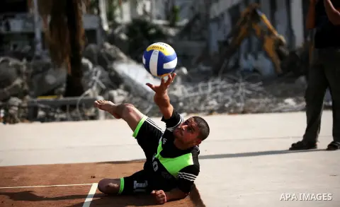 A picture taken on December 3, 2014 shows a disabled Palestinian plays a volleyball match during a training session at Jamal Abdel Nasser UNRWA School which was destroyed during the recent conflict between Israel and Ham...