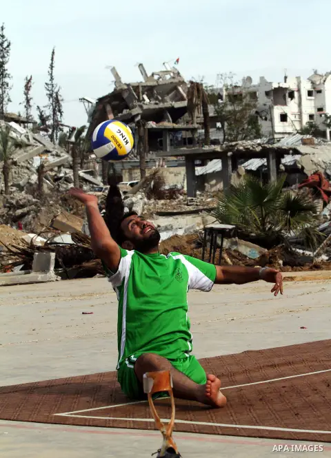 A picture taken on December 3, 2014 shows a disabled Palestinian plays a volleyball match during a training session at Jamal Abdel Nasser UNRWA School which was destroyed during the recent conflict between Israel and Ham...
