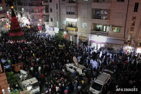 Palestinians celebrate the lighting of the Christmas tree, in the West Bank city of Ramallah, as preparations for Christmas celebrations get underway on December 7, 2014. Photo by Shadi Hatem