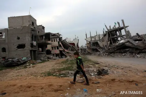 A Palestinian boy walks past the rubbles of houses, which were destroyed during the recent Israeli offensive on Gaza Strip, in Shijaiyah neighborhood, east Gaza City, December 8, 2014. According to housing minister Mufee...