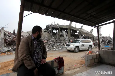 A Palestinian man looks on a U.N. vehicle as he sit in front of the rubbles of his house, which was destroyed during the recent Israeli offensive on Gaza Strip, in Shijaiyah neighborhood, east Gaza City, December 8, 2014...