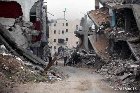 Palestinians walk past the rubbles of houses, which were destroyed during the recent Israeli offensive on Gaza Strip, in Shijaiyah neighborhood, east Gaza City, December 8, 2014. According to housing minister Mufeed al-H...