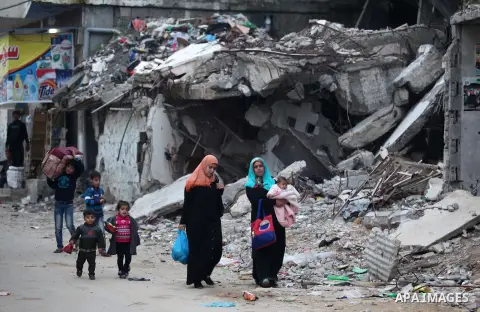 Palestinians walk past the rubbles of houses, which were destroyed during the recent Israeli offensive on Gaza Strip, in Shijaiyah neighborhood, east Gaza City, December 8, 2014. According to housing minister Mufeed al-H...
