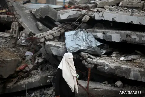 A Palestinian woman walks past the rubbles of houses, which were destroyed during the recent Israeli offensive on Gaza Strip, in Shijaiyah neighborhood, east Gaza City, December 8, 2014. According to housing minister Muf...