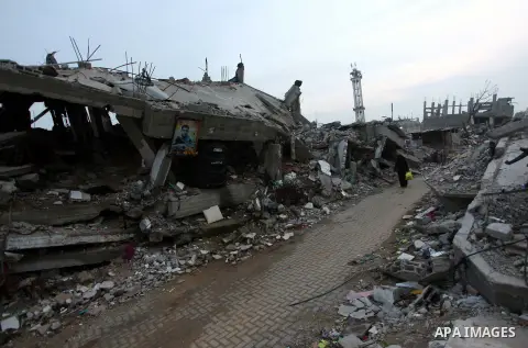 A Palestinian woman walks past the rubbles of houses, which were destroyed during the recent Israeli offensive on Gaza Strip, in Shijaiyah neighborhood, east Gaza City, December 8, 2014. According to housing minister Muf...