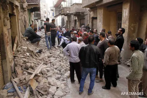 Egyptians and rescue workers inspect the site of a collapsed two-storey building in the Cairo district of Torgoman, December 9, 2014. The Ministry of Health and Population of Egypt injuring two people in the collapse of...