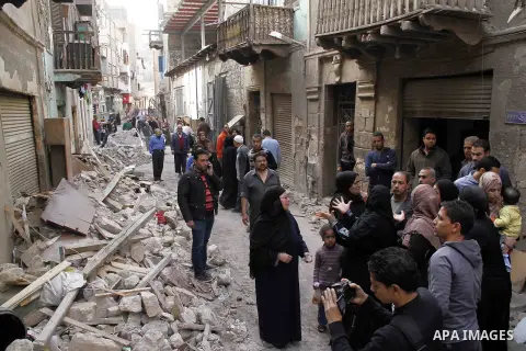 Egyptians and rescue workers inspect the site of a collapsed two-storey building in the Cairo district of Torgoman, December 9, 2014. The Ministry of Health and Population of Egypt injuring two people in the collapse of...