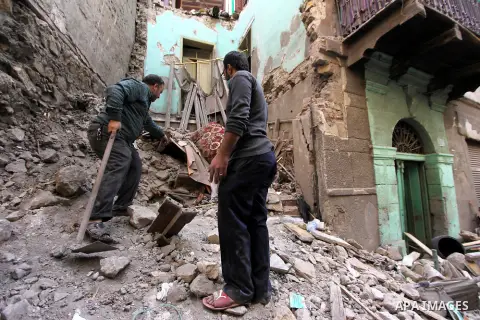 Egyptians and rescue workers inspect the site of a collapsed two-storey building in the Cairo district of Torgoman, December 9, 2014. The Ministry of Health and Population of Egypt injuring two people in the collapse of...