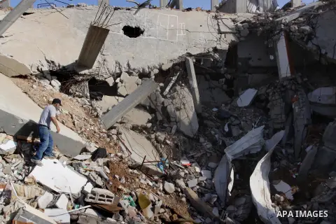 Palestinian workers remove the ruins of houses which were destroyed during the seven-week Israeli offensive on Gaza Strip, in Shijaeya neighborhood, east of Gaza city, December 10, 2014. According to housing minister Muf...