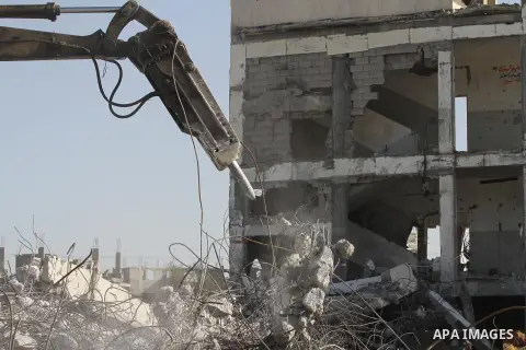 Palestinian workers use a bulldozer to remove the ruins of houses which were destroyed during the seven-week Israeli offensive on Gaza Strip, in Shijaeya neighborhood, east of Gaza city, December 10, 2014. According to h...