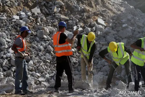 Palestinian workers remove the ruins of houses which were destroyed during the seven-week Israeli offensive on Gaza Strip, in Shijaeya neighborhood, east of Gaza city, December 10, 2014. According to housing minister Muf...