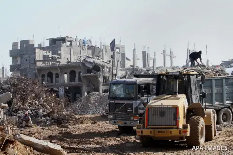 Palestinian workers use a bulldozer to remove the ruins of houses which were destroyed during the seven-week Israeli offensive on Gaza Strip, in Shijaeya neighborhood, east of Gaza city, December 10, 2014. According to h...