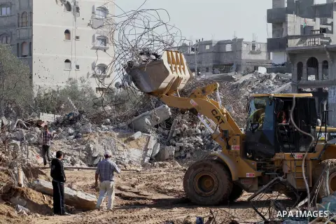Palestinian workers use a bulldozer to remove the ruins of houses which were destroyed during the seven-week Israeli offensive on Gaza Strip, in Shijaeya neighborhood, east of Gaza city, December 10, 2014. According to h...