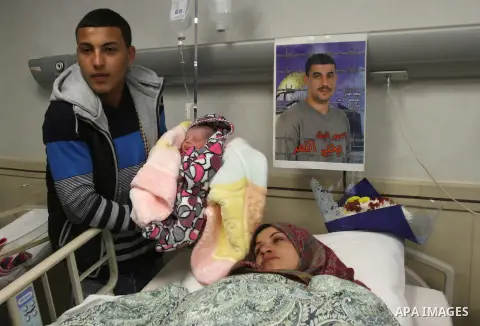Samira, the wife of Palestinian prisoner Yahya al-Nemer, lies on a bed next to her baby girl Yasmeen, who was conceived with al-Nemer sperm smuggled out of an Israeli prison, at a hospital in the West Bank City of Nablus...