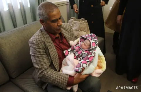 The Father of Palestinian prisoner Yahya al-Nemer hold his granddaughter at a hospital in the West Bank City of Nablus December 12, 2014. Samira gave birth to her baby girl in a successful smuggling of sperm to lead to a...