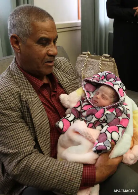The Father of Palestinian prisoner Yahya al-Nemer hold his granddaughter at a hospital in the West Bank City of Nablus December 12, 2014. Samira gave birth to her baby girl in a successful smuggling of sperm to lead to a...