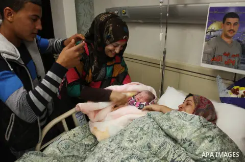 Samira, the wife of Palestinian prisoner Yahya al-Nemer, lies on a bed next to her baby girl Yasmeen, who was conceived with al-Nemer sperm smuggled out of an Israeli prison, at a hospital in the West Bank City of Nablus...