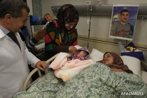Samira, the wife of Palestinian prisoner Yahya al-Nemer, lies on a bed next to her baby girl Yasmeen, who was conceived with al-Nemer sperm smuggled out of an Israeli prison, at a hospital in the West Bank City of Nablus...
