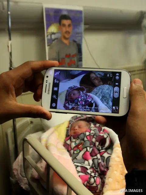Samira, the wife of Palestinian prisoner Yahya al-Nemer, lies on a bed next to her baby girl Yasmeen, who was conceived with al-Nemer sperm smuggled out of an Israeli prison, at a hospital in the West Bank City of Nablus...
