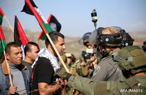 A Palestinian man argues with An Israeli guard during a demonstration intended to plant 300 olive trees in the village of Turmus Aya near Ramallah, in the Isareli-occupied West Bank, on December 10, 2014. Ziad Abu Ein, w...