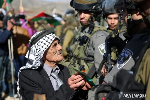 A Palestinian man argues with An Israeli guard during a demonstration intended to plant 300 olive trees in the village of Turmus Aya near Ramallah, in the Isareli-occupied West Bank, on December 10, 2014. Ziad Abu Ein, w...
