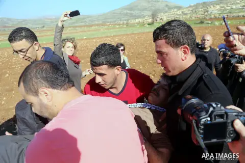 Palestinian protesters treat Palestinian official Ziad Abu Ein, in charge of the issue of Israeli settlements for the Palestinian Authority, as he lays on the ground after being beaten by Israeli soldiers, during a demon...