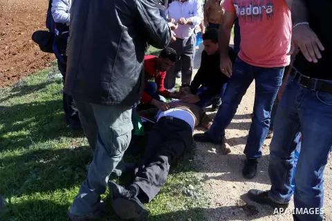 Palestinian protesters treat Palestinian official Ziad Abu Ein, in charge of the issue of Israeli settlements for the Palestinian Authority, as he lays on the ground after being beaten by Israeli soldiers, during a demon...