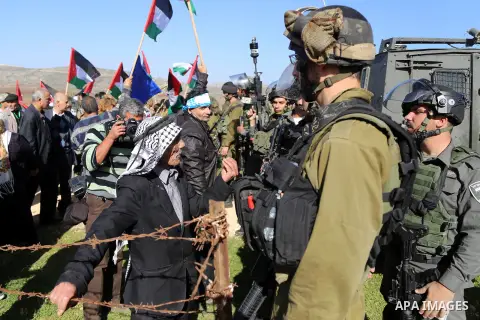 A Palestinian man argues with An Israeli guard during a demonstration intended to plant 300 olive trees in the village of Turmus Aya near Ramallah, in the Isareli-occupied West Bank, on December 10, 2014. Ziad Abu Ein, w...