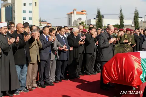 Palestinian President Mahmoud Abbas prays next to the coffin of Palestinian minister Ziad Abu Ein during his funeral in the West Bank city of Ramallah on December 11, 2014. Thousands of Palestinians gathered to mourn Abu...