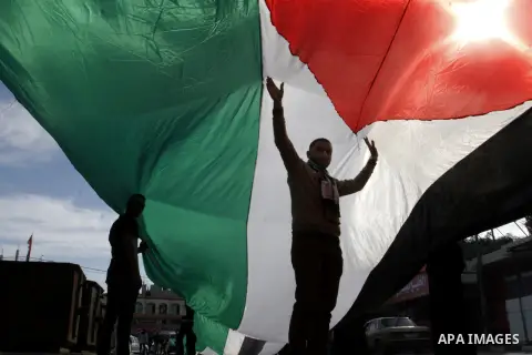 Palestinians carry a huge flag during a rally in solidarity with al-Aqsa mosque in Jerusalem organised by Palestinian security forces, in Rafah in the southern Gaza Strip, December 11, 2014. Photo by Abed Rahim Khatib