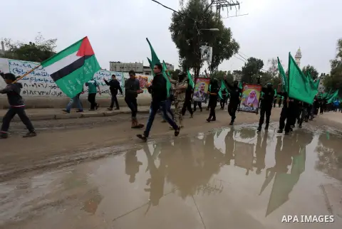 Members of Hamas movement hold the movement's flag as they take part in a rally ahead of the 27th anniversary of Hamas founding, in Shijaiyah in the east of Gaza city December 12, 2014. Photo by Mohammed Asad