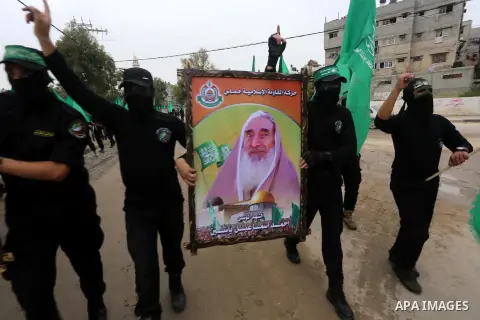 Members of Hamas movement hold the movement's flag as they take part in a rally ahead of the 27th anniversary of Hamas founding, in Shijaiyah in the east of Gaza city December 12, 2014. Photo by Mohammed Asad