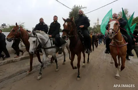 Members of Hamas movement hold the movement's flag as they take part in a rally ahead of the 27th anniversary of Hamas founding, in Shijaiyah in the east of Gaza city December 12, 2014. Photo by Mohammed Asad