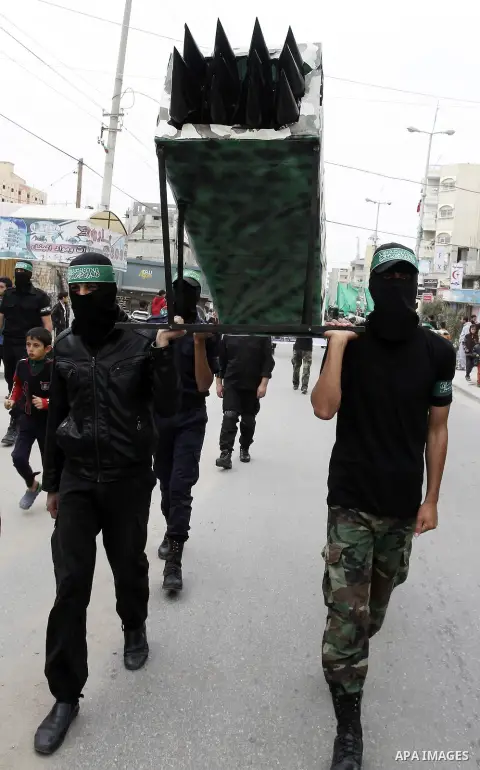 Palestinian militants from the Ezzedine al-Qassam brigade take part during a rally to commemorate the 27th anniversary of the Islamist movement s creation, at the Nuseirat refugee camp in the Central Gaza Strip on Decemb...