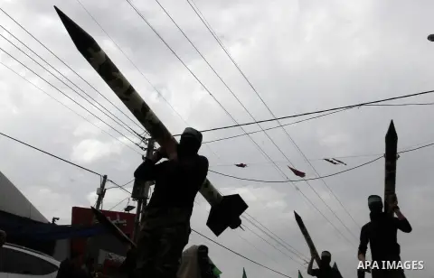 Palestinian militants from the Ezzedine al-Qassam brigade take part during a rally to commemorate the 27th anniversary of the Islamist movement s creation, at the Nuseirat refugee camp in the Central Gaza Strip on Decemb...