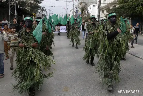 Palestinian militants from the Ezzedine al-Qassam brigade take part during a rally to commemorate the 27th anniversary of the Islamist movement s creation, at the Nuseirat refugee camp in the Central Gaza Strip on Decemb...