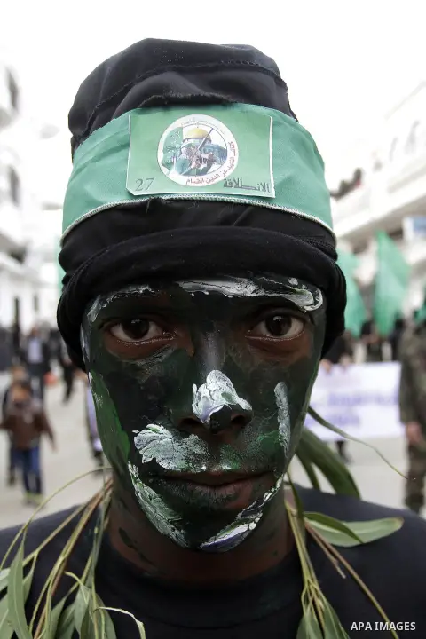 Palestinian militants from the Ezzedine al-Qassam brigade take part during a rally to commemorate the 27th anniversary of the Islamist movement s creation, at the Nuseirat refugee camp in the Central Gaza Strip on Decemb...