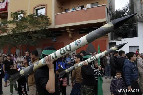 Palestinian militants from the Ezzedine al-Qassam brigade take part during a rally to commemorate the 27th anniversary of the Islamist movement s creation, at the Nuseirat refugee camp in the Central Gaza Strip on Decemb...
