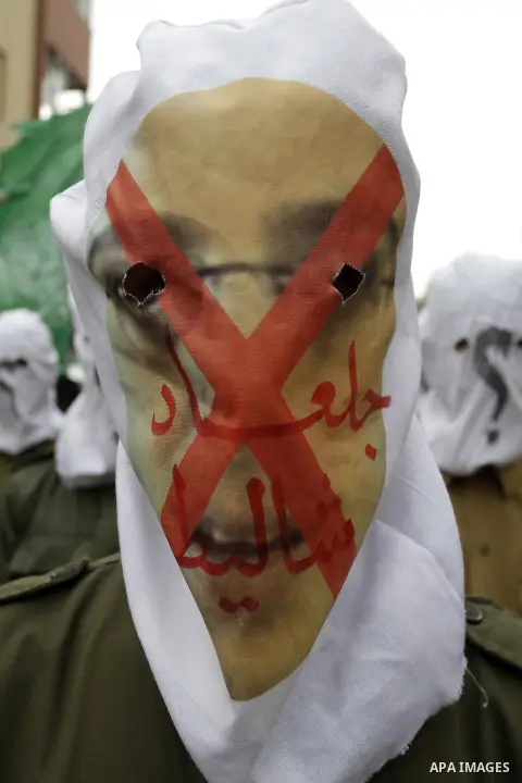 Palestinian militants from the Ezzedine al-Qassam brigade take part during a rally to commemorate the 27th anniversary of the Islamist movement s creation, at the Nuseirat refugee camp in the Central Gaza Strip on Decemb...