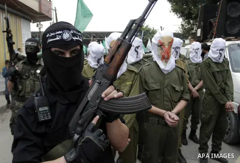 Palestinian militants from the Ezzedine al-Qassam brigade take part during a rally to commemorate the 27th anniversary of the Islamist movement s creation, at the Nuseirat refugee camp in the Central Gaza Strip on Decemb...