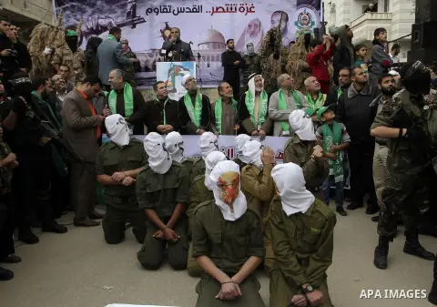 Palestinian militants from the Ezzedine al-Qassam brigade take part during a rally to commemorate the 27th anniversary of the Islamist movement s creation, at the Nuseirat refugee camp in the Central Gaza Strip on Decemb...