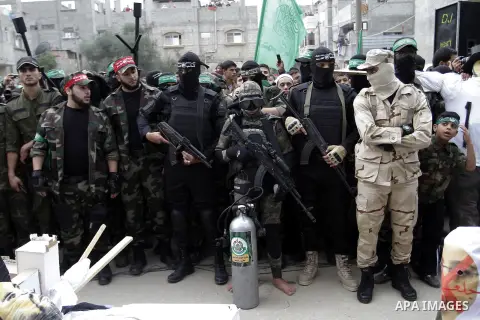 Palestinian militants from the Ezzedine al-Qassam brigade take part during a rally to commemorate the 27th anniversary of the Islamist movement s creation, at the Nuseirat refugee camp in the Central Gaza Strip on Decemb...