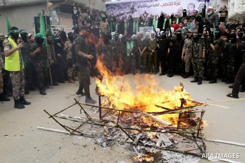 Palestinian militants from the Ezzedine al-Qassam brigade burn symbolic coffins with Israeli flags and effigies depicting Israeli settlers during a rally to commemorate the 27th anniversary of the Islamist movement s cre...