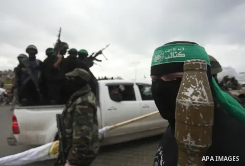 Palestinian members of the marine unit of al-Qassam Brigades, the armed wing of the Hamas movement, ride in a pickup truck as they take part in a military parade marking the 27th anniversary of Hamas' founding, in Gaza C...