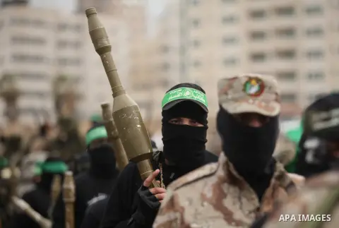 Palestinian members of al-Qassam Brigades, the armed wing of the Hamas movement, hold weapons as they take part in a military parade marking the 27th anniversary of Hamas' founding, in Gaza City December 14, 2014. Photo...