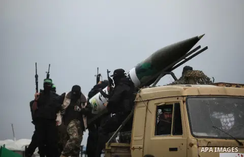 Palestinian members of al-Qassam Brigades, the armed wing of the Hamas movement, display a home-made Qassam rocket during a military parade marking the 27th anniversary of Hamas' founding, in Gaza City December 14, 2014....