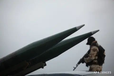 Palestinian members of al-Qassam Brigades, the armed wing of the Hamas movement, display a home-made Qassam rocket during a military parade marking the 27th anniversary of Hamas' founding, in Gaza City December 14, 2014....